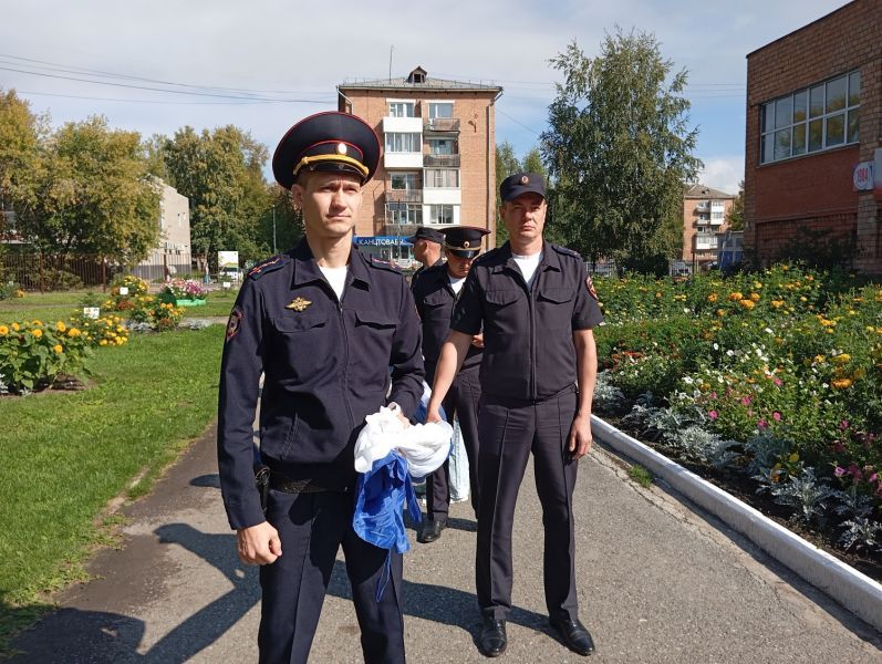 В Назарово полицейские вместе со школьниками развернули 20-метровый триколор в честь Дня российского флага